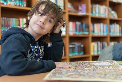 Little boy reading in a library